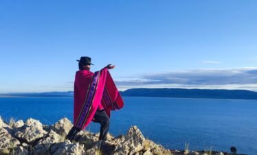Andean wise man offering to Pachamama on Luquina Chico hill overlooking Lake Titicaca in Puno, Peru