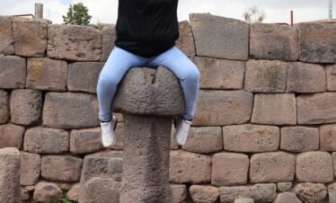Visitor experiencing ancestral symbolism at Inca Uyo Fertility Temple in Chucuito near Lake Titicaca Puno Peru