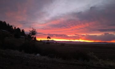 Evening colors reflecting on Lake Titicaca as sun sets behind Luquina Chico in Puno, Peru
