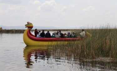 Visitors on a traditional totora reed boat ride at Uros Islands, Lake Titicaca, Peru