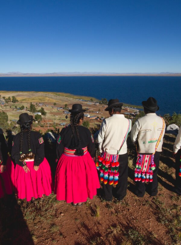 Community members gazing at Lake Titicaca and surrounding hills in Luquina Chico, Puno, Peru