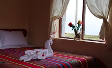 Spacious matrimonial bed with private bathroom and 24-hour hot shower in Luquina Chico, Lake Titicaca, Peru