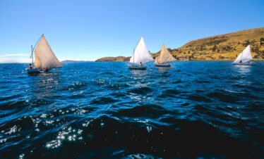 Traditional sailboats gliding across Lake Titicaca near Luquina Chico in Puno, Peru