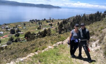 Couple walking along the highest hill path in Luquina Chico overlooking Lake Titicaca, Peru